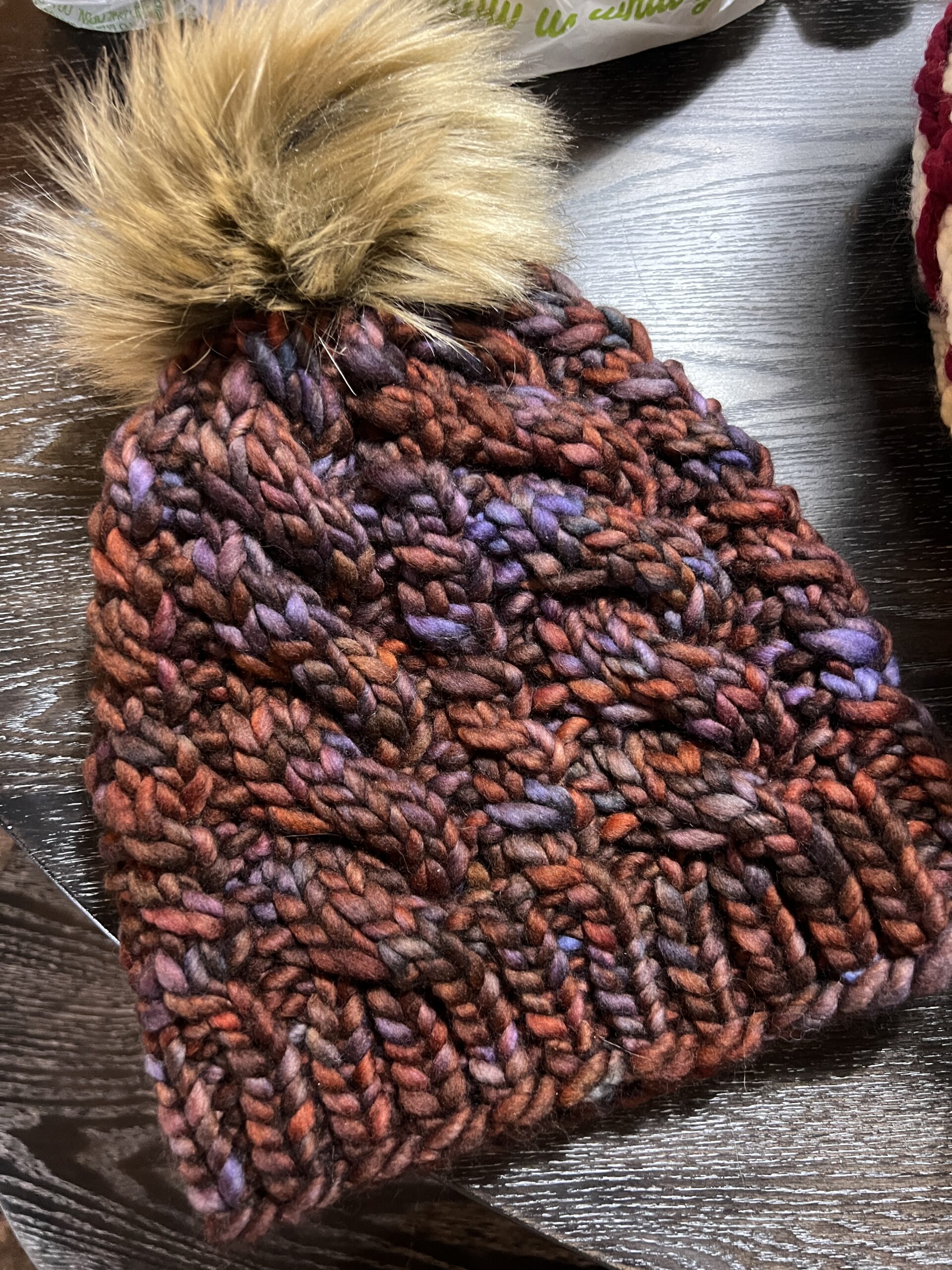 chunky cable merino wool hat with a brown pom